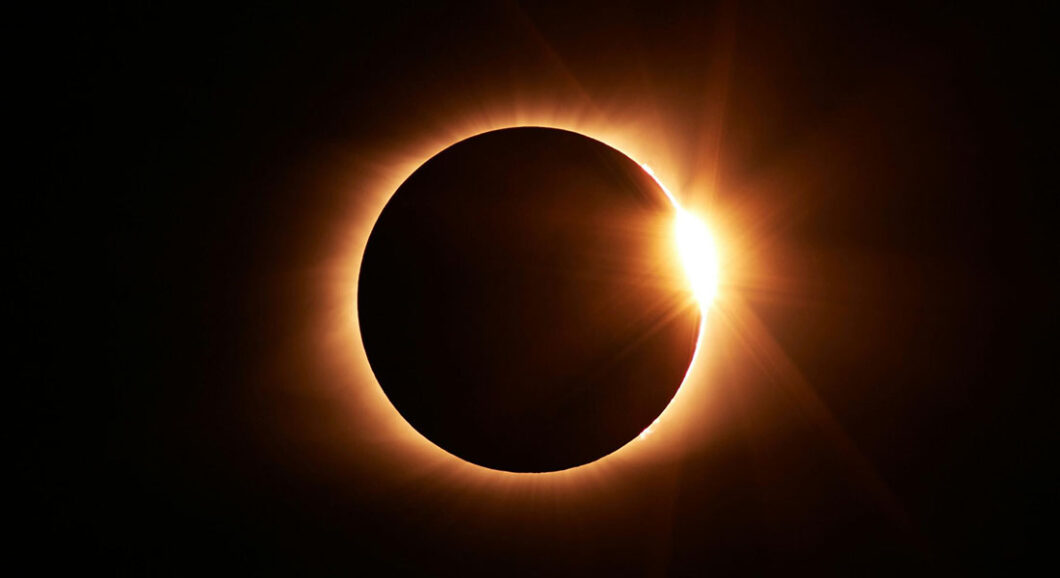 Eclipse solar total en el momento del efecto anillo de diamantes, con la luna cubriendo el disco solar y un destello de luz radiante.
